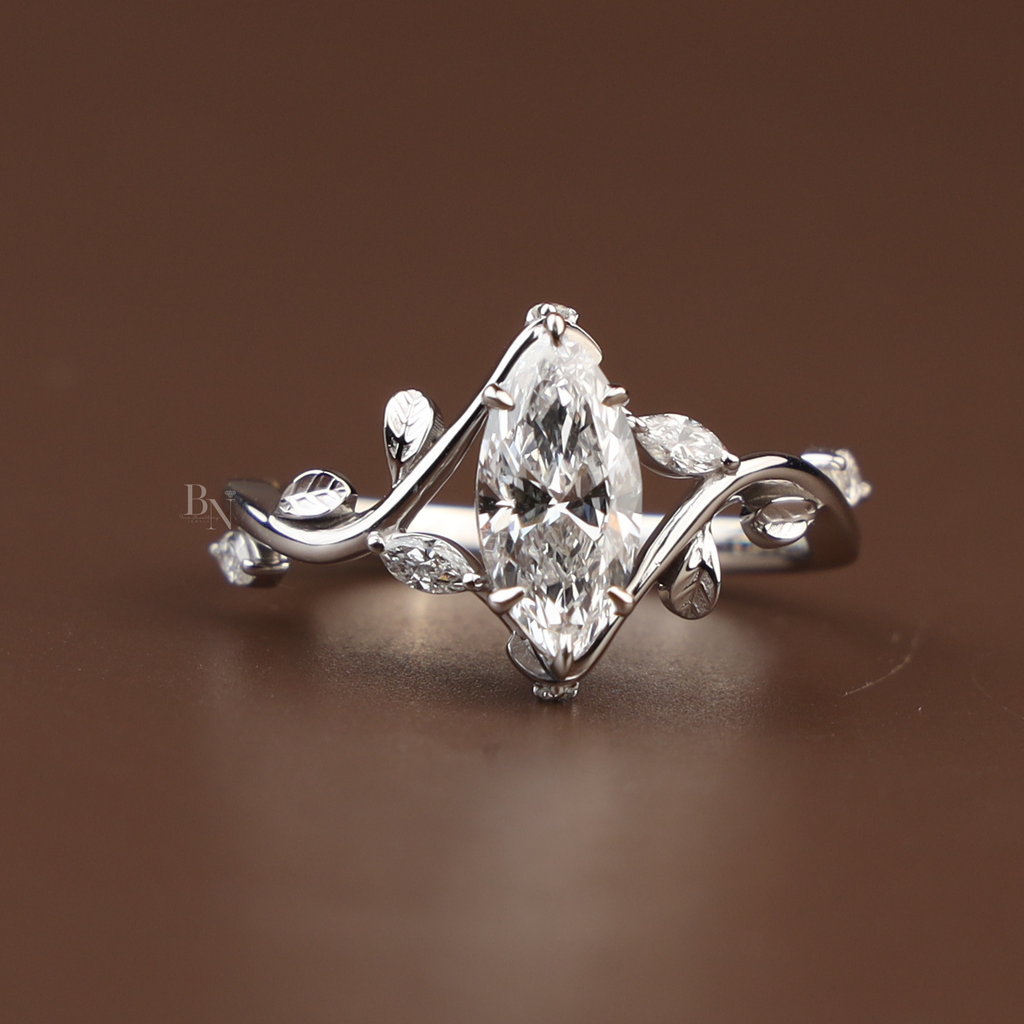 1 carat marquise cut lab grown diamond engagement ring in 14k white gold featuring a nature-inspired vine and leaf filigree setting with small marquise side accents on a high-polish band.
