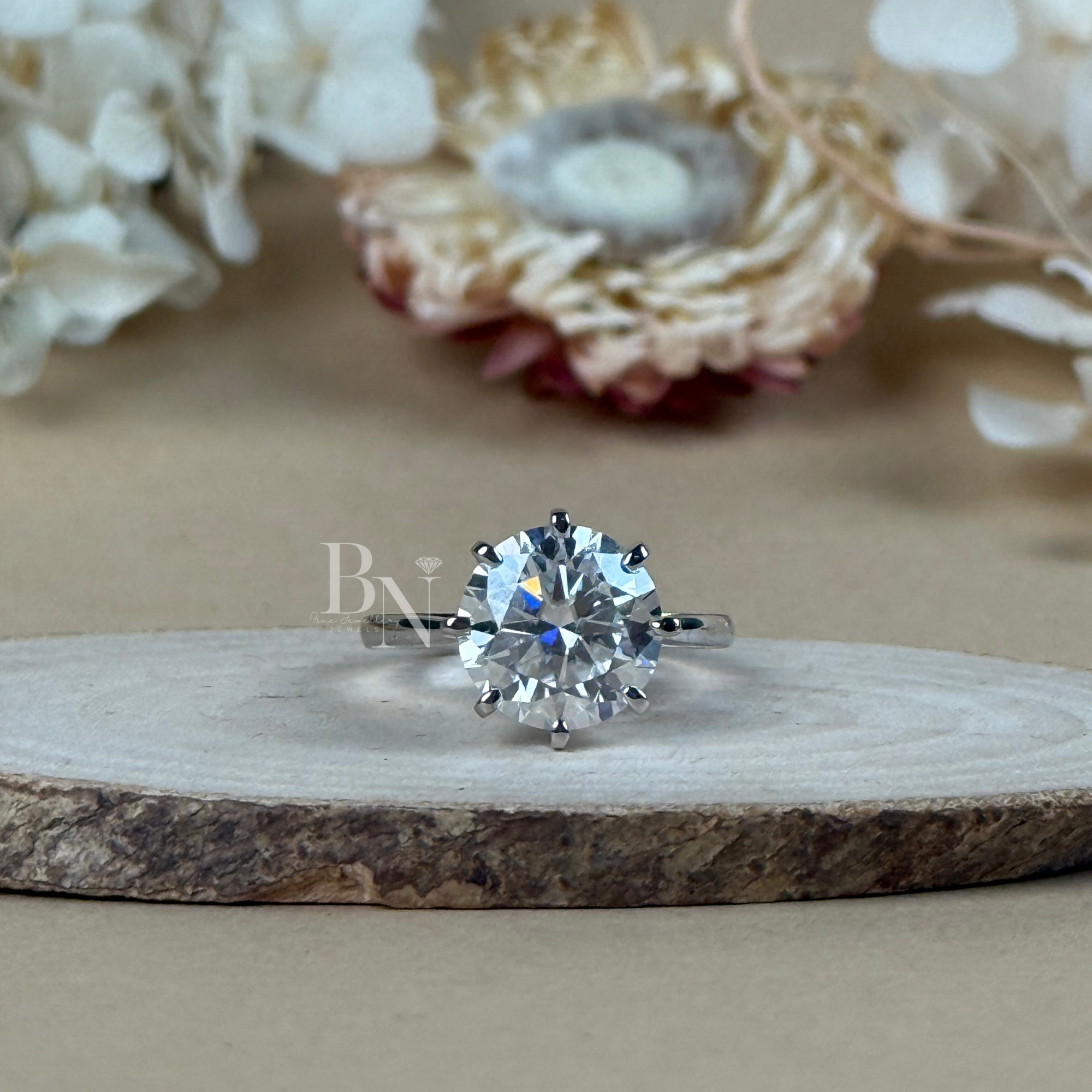 4 carat round brilliant cut lab grown diamond engagement ring in a 14k white gold 6 prong solitaire setting on a wooden surface showing exceptional icy white brilliance and professional craftsmanship.