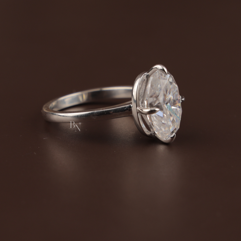 7.00 carat oval moissanite solitaire ring in 14k white gold. The stone features a crushed ice cut with intense rainbow fire and kaleidoscopic sparkle, set in a minimal six-prong high-profile mount.