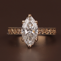 2 carat marquise cut lab grown diamond set in a 14k rose gold vintage cathedral setting with intricate filigree engraving, milgrain details, and a sparkling hidden halo under the center stone.