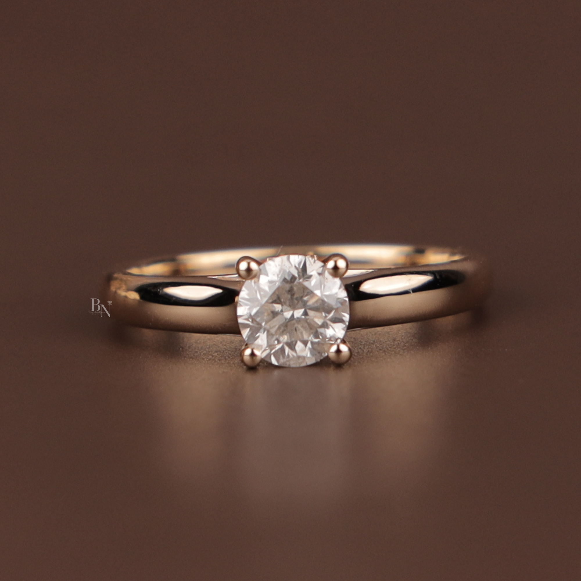 Close up of a round brilliant cut lab grown diamond engagement ring in yellow gold featuring a hidden halo setting and micro pave diamonds along the polished band for a classic bridal aesthetic