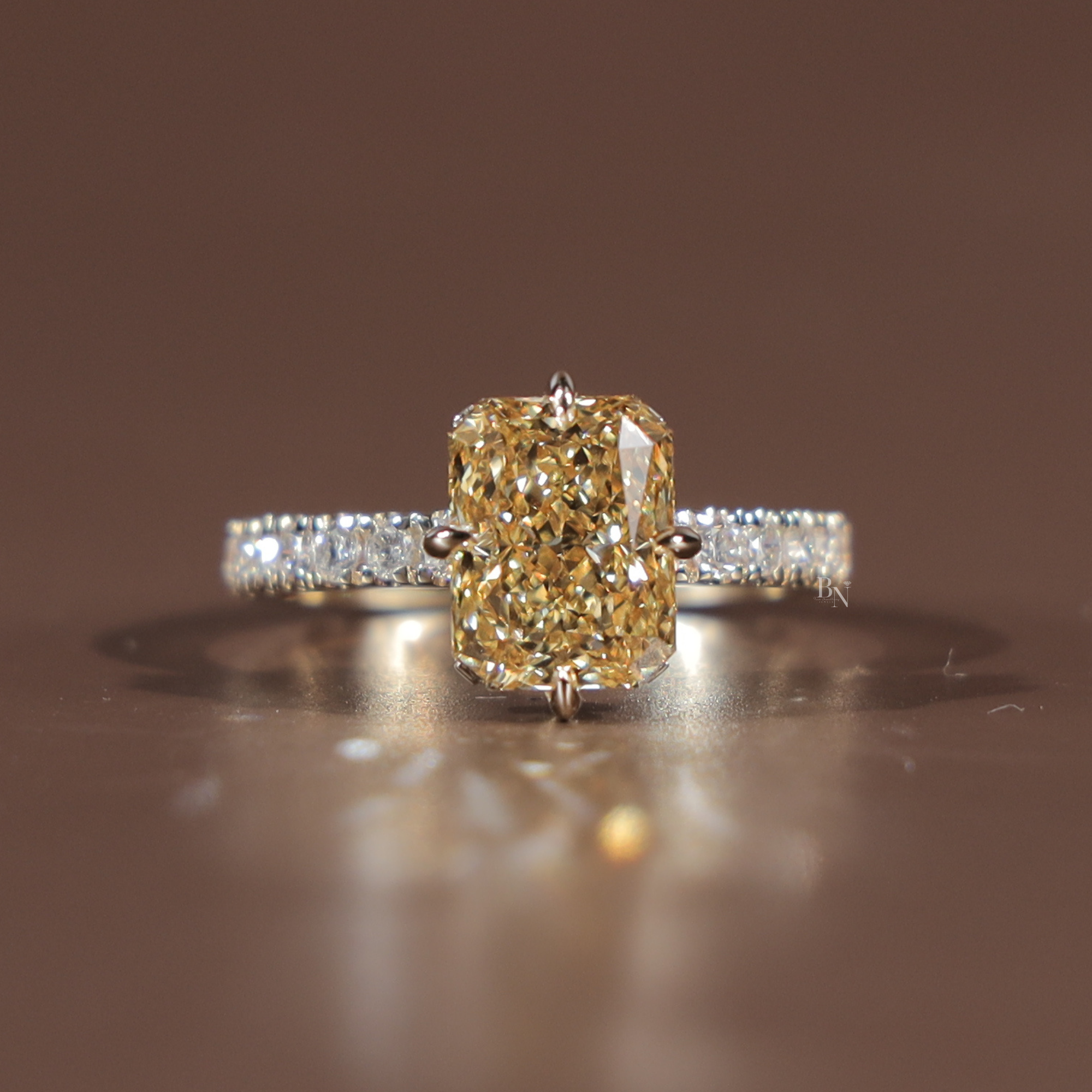 Side profile of a 3.5 carat elongated radiant cut fancy yellow lab grown diamond engagement ring featuring a sparkling hidden halo and a delicate white gold pave band with canary yellow diamond brilliance and Type IIa clarity.