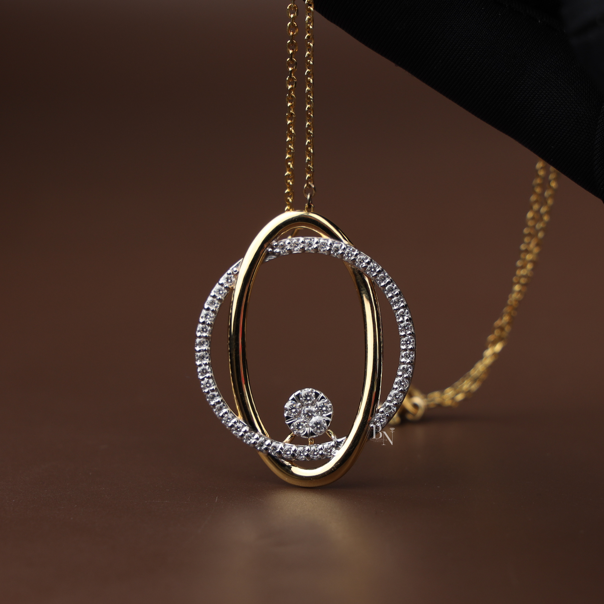 Front view of a 1.50 carat total weight lab grown diamond jewelry set featuring an interlocking oval pendant on a gold chain and matching halo stud earrings on a natural wood surface with 14k gold hallmark.