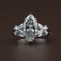 Side profile of a 3.50 carat marquise lab diamond engagement ring in 14k white gold featuring butterfly-shaped marquise side stone clusters and a decorative high-profile basket setting with v-shaped prongs.
