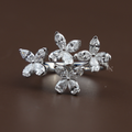 Top view of 2 carat total weight lab grown diamond butterfly ring featuring marquise cut diamonds in a cluster floral setting on a 14k white gold bypass band with pavé diamond accents worn on a hand with red nails.