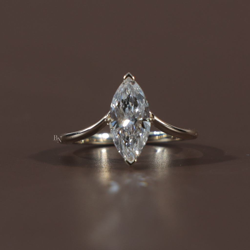 1.50 carat marquise cut lab grown diamond engagement ring in 14k white gold featuring a hidden halo under-setting and a polished tapered cathedral band shown on a hand and black silk background for luxury scale and detail.