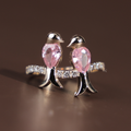 Two pear cut pink lab grown diamonds shaped as birds perched on a 14k white gold pavé branch band with round brilliant accent diamonds, romantic nature inspired bypass ring design for women.