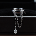Unique lab grown diamond ring in 14k white gold featuring a wide polished band with two pavé diamond collars holding a draped cable chain with a dangling pear cut teardrop diamond lariat.