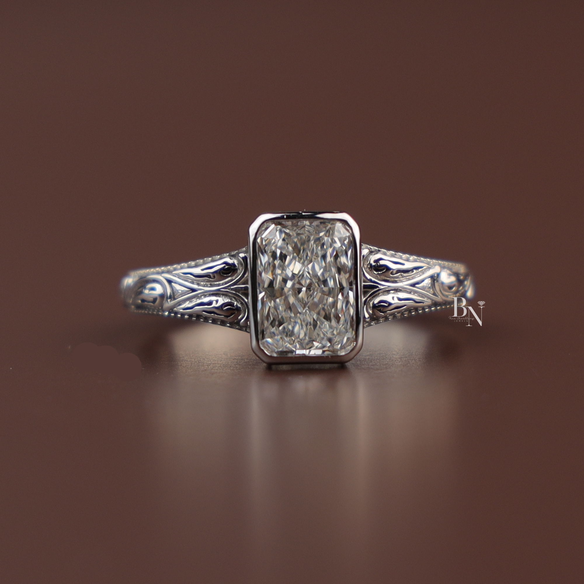 A 1.50 carat radiant cut lab grown diamond solitaire engagement ring in a vintage-inspired platinum bezel setting featuring intricate hand-engraved scrollwork along the band viewed from multiple side and top profile angles.