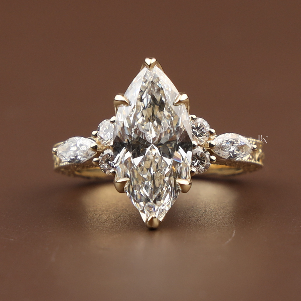 3 carat marquise cut lab grown diamond engagement ring in 14k yellow gold featuring an intricate hand-engraved vintage filigree band with floral scrollwork and a six-prong lotus flower cathedral setting.