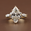 3 carat marquise cut lab grown diamond engagement ring in 14k yellow gold featuring an intricate hand-engraved vintage filigree band with floral scrollwork and a six-prong lotus flower cathedral setting.