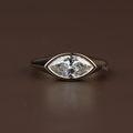 1.25 carat marquise cut lab grown diamond engagement ring in a sleek horizontal east-west bezel setting, crafted in polished 14k yellow gold on a minimalist band.