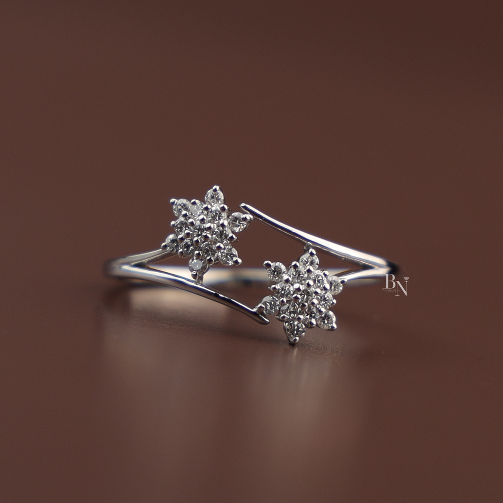An elegant white gold open bypass ring featuring two sparkling round lab grown diamond star clusters on a delicate polished shank, viewed from multiple angles on a display and a hand.