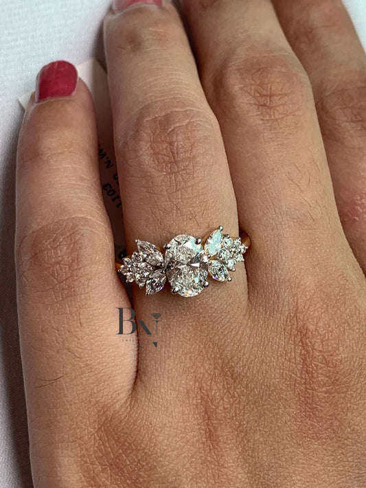 Hand modeling a unique oval butterfly engagement ring. The 1-carat oval diamond is flanked by wing-like clusters of marquise and round diamonds in 14k gold