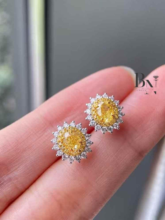 0.50 CT Fancy Yellow Oval Lab Grown Diamond Halo Stud Earrings in a two-tone gold sunflower setting.