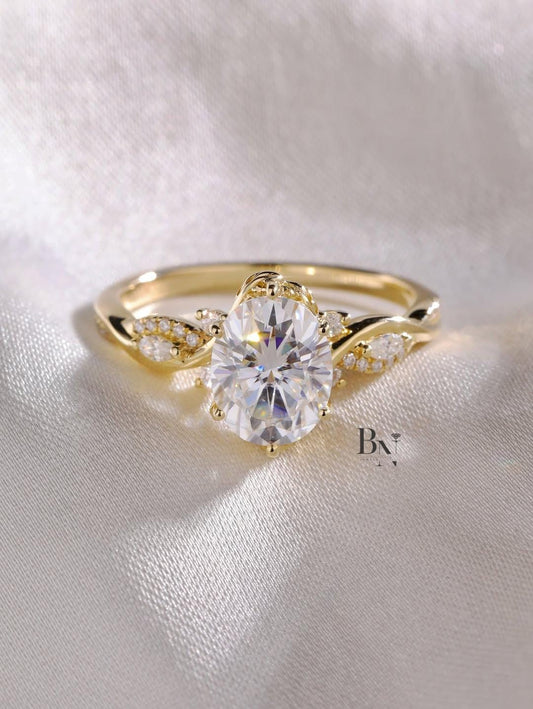 A 1 carat oval lab diamond engagement ring with a nature-inspired twisted vine band and leaf-shaped diamond accents in 14k yellow gold.