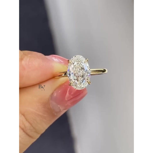 3.00 carat oval cut lab grown diamond engagement ring with a hidden halo on a classic yellow gold solitaire band.