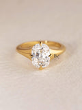 An incredible 2 carat elongated Old Mine cushion cut lab-grown diamond ring held in a box. This ethical statement ring is crafted in a modern, minimalist 14K yellow gold solitaire setting with four compass-style prongs.