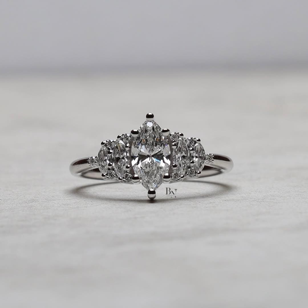 Close-up of a 1 CTW marquise and round lab diamond cluster ring in a jewelry box. The intricate five-stone design sparkles brilliantly in 14K white gold, highlighting its vintage, Art Deco-inspired craftsmanship and detail.