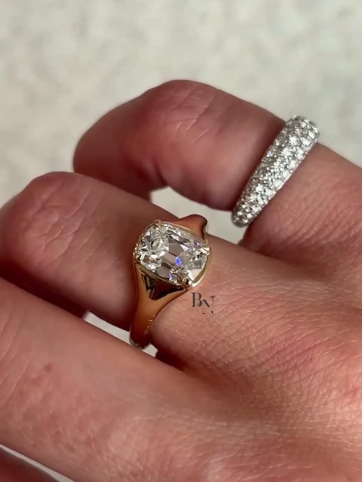 Close-up of a 2 carat Old Mine Cut lab diamond signet-style ring. The IGI certified antique-cut diamond is set in a thick, polished yellow gold bezel, showcasing its chunky, modern, and luxurious design.