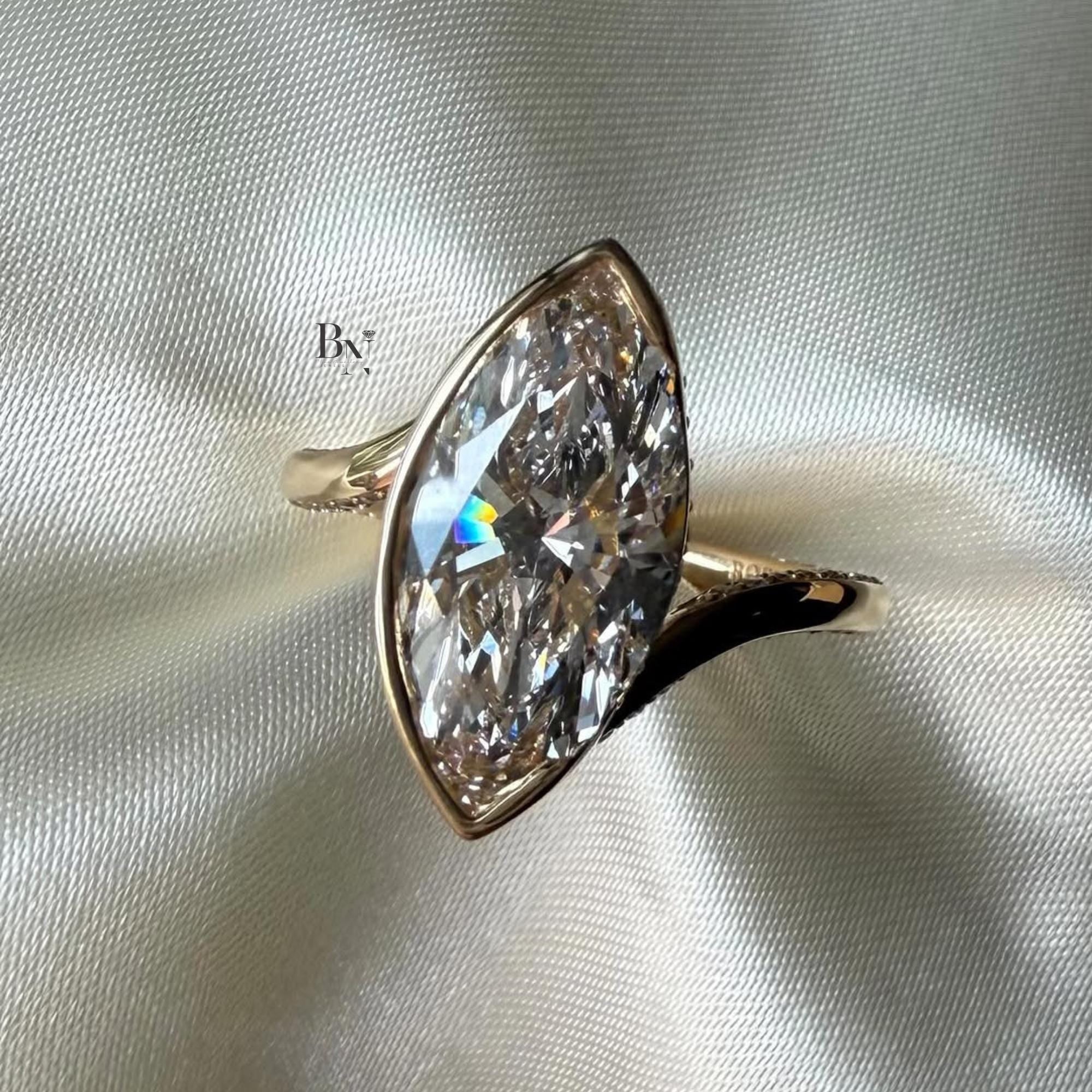 Macro shot of a large 3.00 carat marquise lab diamond engagement ring in rose gold, featuring a bezel setting with hidden halo detail and a pave twisted bypass band.