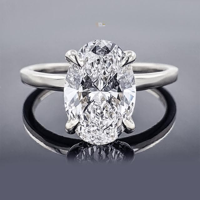 Side profile of 1.5 carat Oval Cut Lab Grown Diamond ring with a hidden halo pave accent and thin, polished white gold solitaire band, emphasizing the high-set head.