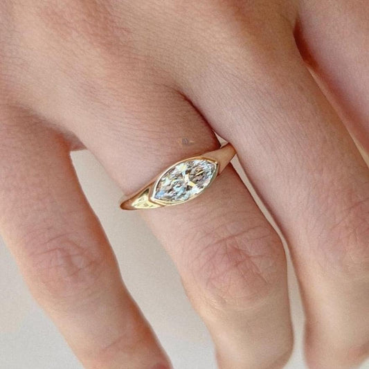 Hand-model view of 1.2 carat Marquise Cut Lab Grown Diamond ring set horizontally (East-West) in a half-bezel tension style on a sleek, high-polish yellow gold band.