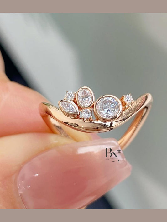 Dainty 0.50ct lab grown diamond contour wedding band in 14k rose gold. Features a cluster of bezel set round, oval, and marquise mixed cut accent stones.