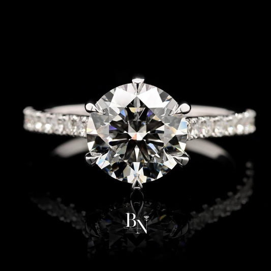 Elegant 1.00ct round brilliant lab grown diamond engagement ring in 14k yellow gold. Features a unique swirl bypass setting with a micro pave accent shank.