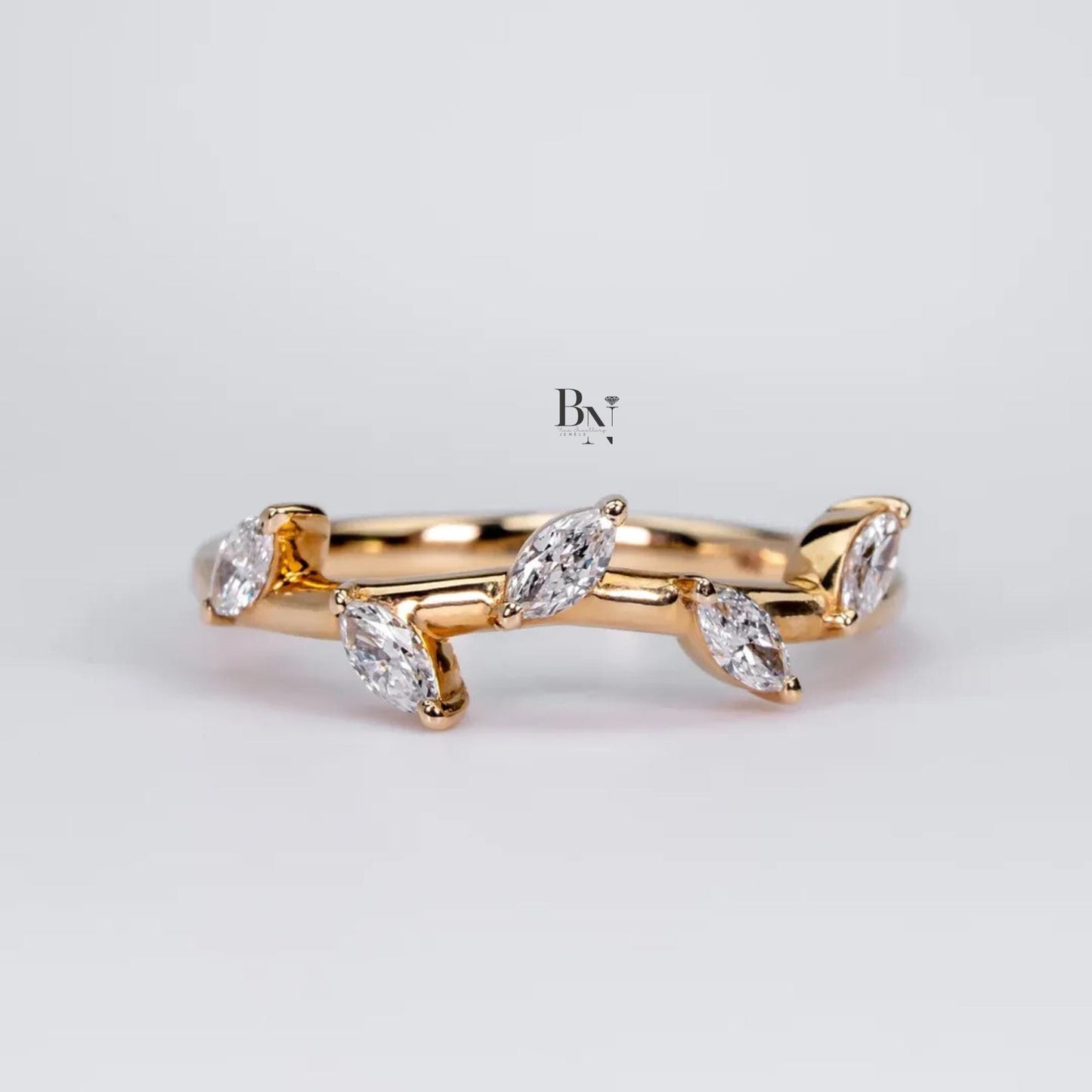 Dainty 0.20ctw marquise cut lab grown diamond wedding band in 14k yellow gold. Features a delicate, nature-inspired vine and leaf design, perfect for stacking.