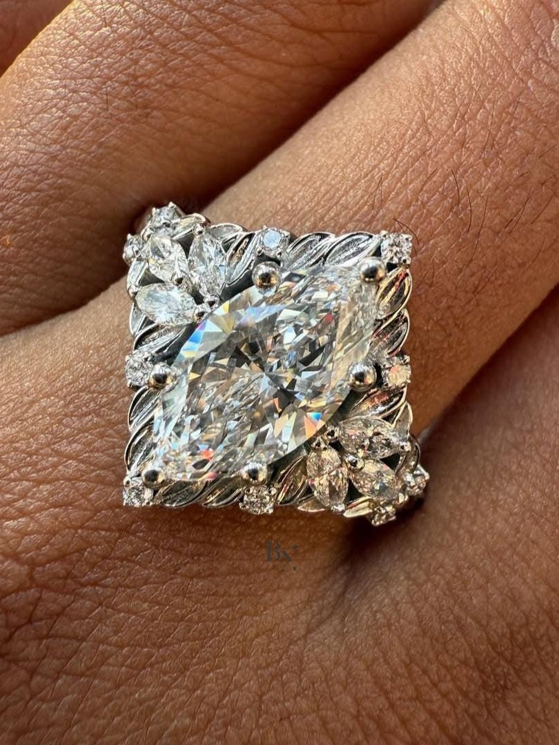 Close-up of 1.50 carat Marquise cut lab grown diamond set in a unique White Gold Nature-Inspired setting, framed by delicate leaf-shaped diamond accents and filigree work.