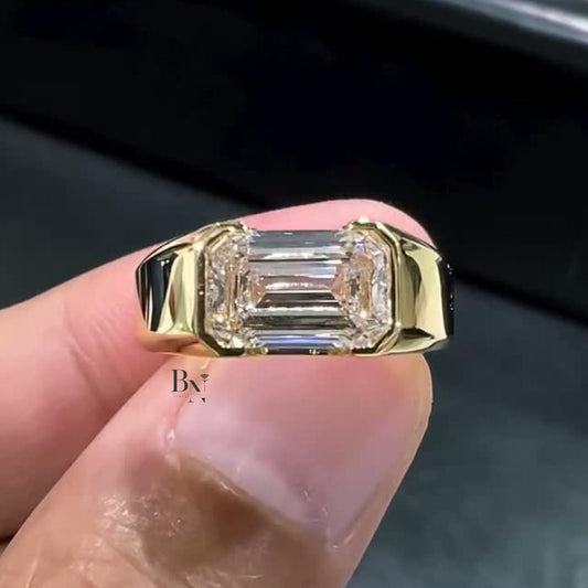 Detailed view of a 3.00ct crushed ice emerald cut moissanite men's ring in yellow gold, highlighting the bezel setting and subtle, diamond-like scintillation.