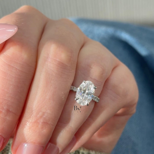 1.00 carat oval lab diamond set in a sculptural yellow gold bypass engagement ring, featuring a semi-bezel setting for a sleek, modern, and low-profile look.