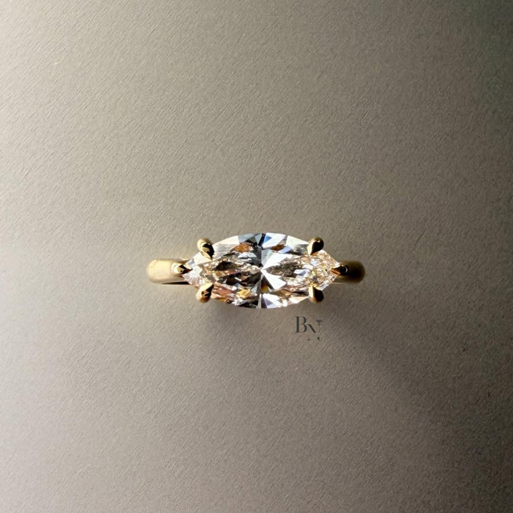 Exquisite 3.00ct horizontal marquise cut lab grown diamond engagement ring in 14k yellow gold. Features an east west setting with a dainty graduated pave accent band.