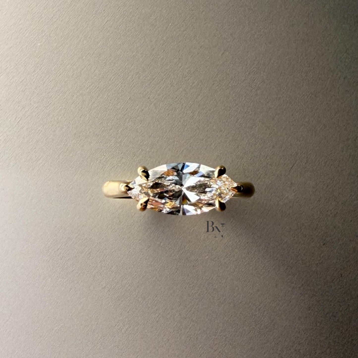 Exquisite 3.00ct horizontal marquise cut lab grown diamond engagement ring in 14k yellow gold. Features an east west setting with a dainty graduated pave accent band.