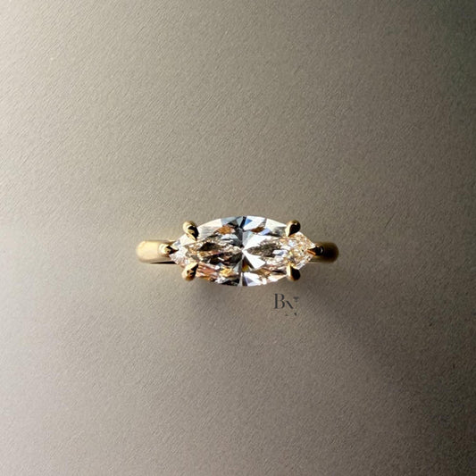 Exquisite 3.00ct horizontal marquise cut lab grown diamond engagement ring in 14k yellow gold. Features an east west setting with a dainty graduated pave accent band.